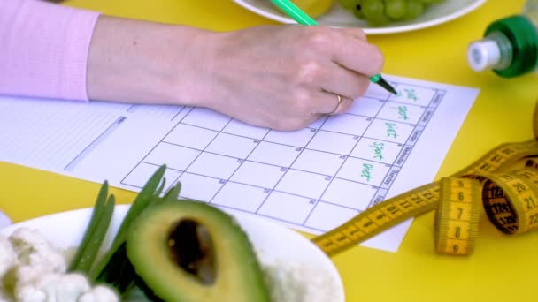 Fitness-Kalender halten. Konzept der gesunden Ernährung, Ernährung, Draufsicht, gelber Hintergrund — Stockvideo