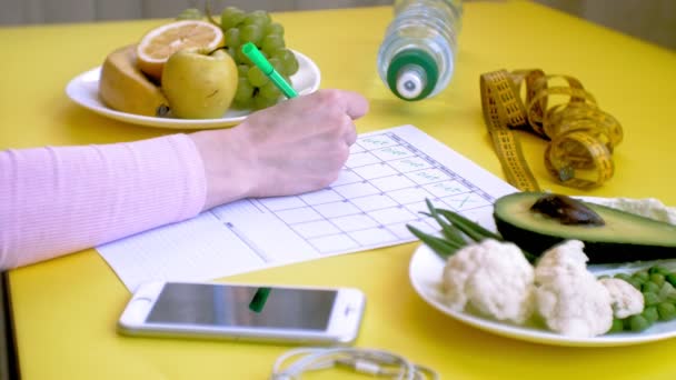 Mantenere un calendario fitness. Concetto di cibo sano, dieta, vista dall'alto, sfondo giallo — Video Stock