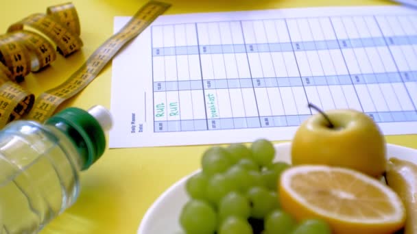 Mantendo um calendar.concept fitness de alimentos saudáveis, dieta, vista superior, fundo amarelo — Vídeo de Stock