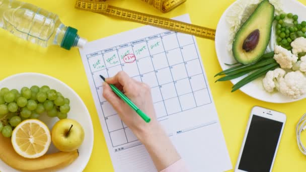 Mantener un calendario de acondicionamiento.concepto de alimentación saludable, dieta, vista superior, fondo amarillo — Vídeo de stock