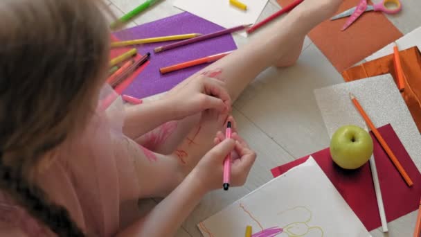 Μικρό κορίτσι ζωγραφίζει στα πόδια της με στυλό, παιδικά δημιουργικότητα, ανάπτυξη — Αρχείο Βίντεο