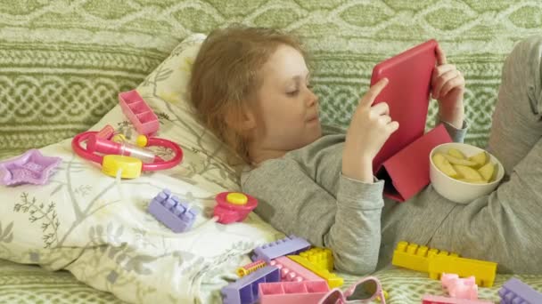 Little girl uses a computer tablet in the interior — Stock Video