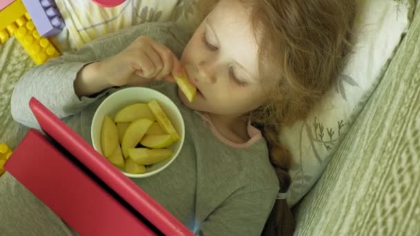 Niña utiliza una tableta de ordenador en el interior — Vídeo de stock