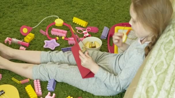 Little girl uses a computer tablet in the interior — Stock Video