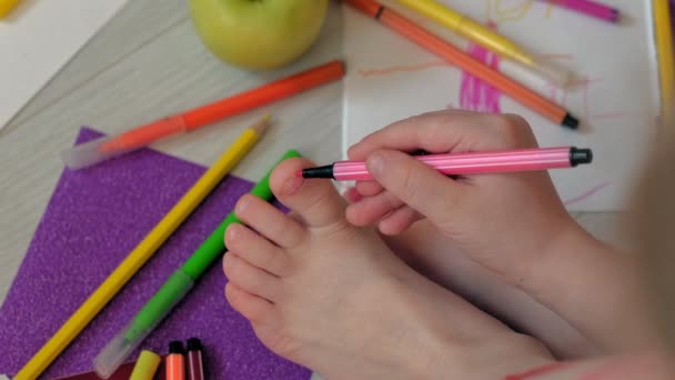 Liten flicka drar på fötterna med filt-Tip pennor, barnens kreativitet, utveckling — Stockvideo