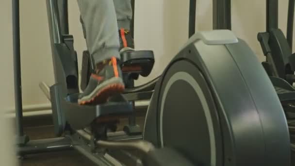 Homme avec machine elliptique dans la salle de gym . — Video