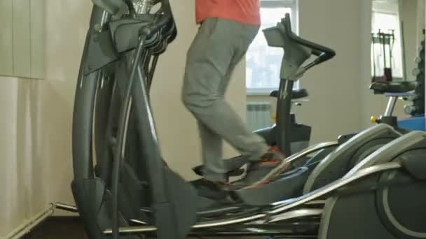 Людина з еліптичною машиною в спортзалі . — стокове відео