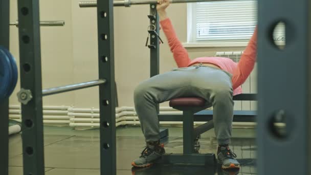 Man doing bench press in fitness studio — Stock Video