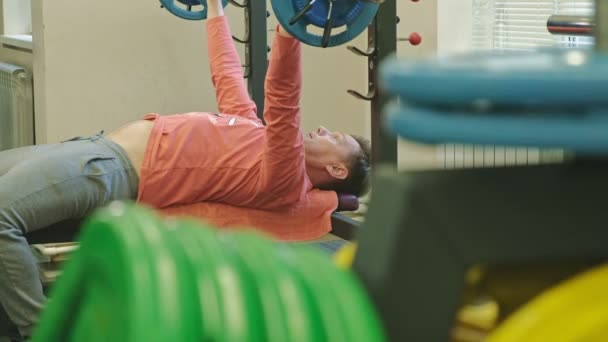 Hombre haciendo press de banca en gimnasio — Vídeos de Stock