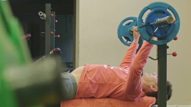 Homme faisant banc de presse dans un studio de fitness — Video