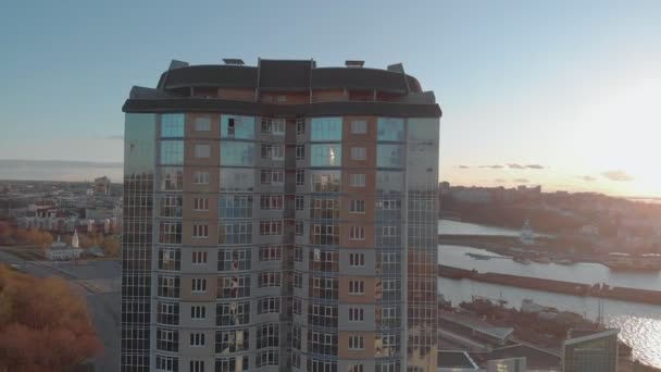 Stadtbild. Wohnanlage am Ufer des Flusses. Luftaufnahmen von einem Hubschrauber bei Sonnenuntergang — Stockvideo