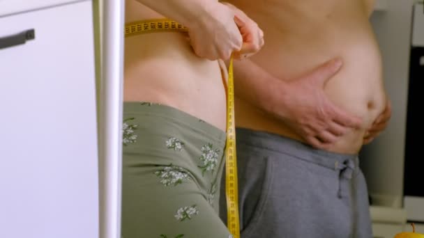 Χοντρός άνθρωπος και λεπτή γυναίκα που μετρά τη μέση του, υγιεινή διατροφή, υγιεινό τρόπο ζωής έννοια, δίαιτα γυμναστικής — Αρχείο Βίντεο