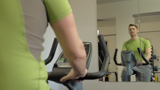 Hombre en bicicleta estática en el gimnasio. concepto de estilo de vida saludable — Vídeo de stock