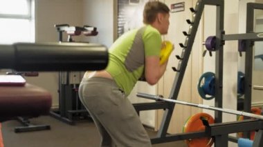 Kilolu adam bir halter için bir ağırlık diski ile squats ile çömelme yok. Fitness eğitimi. Sağlıklı yaşam tarzı kavramı