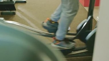 spor salonunda eliptik makine ile adam.