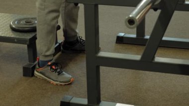 Kilolu adam bir halter için bir ağırlık diski ile squats ile çömelme yok. Fitness eğitimi. Sağlıklı yaşam tarzı kavramı