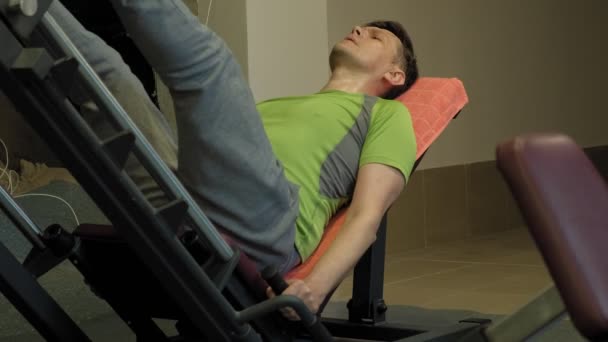 Człowiek z nadwagą robi naciśnie nóg na symulatorze w siłowni. Trening fitness. Koncepcja zdrowego stylu życia — Wideo stockowe