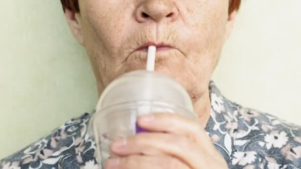 Vieille femme boire un verre à partir d'une paille gros plan — Video