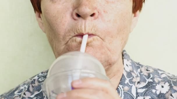 Vieille femme boire un verre à partir d'une paille gros plan — Video