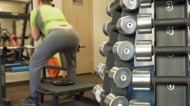 The overweight man does squats with squats with a weight disc for a barbell. Fitness training. Healthy lifestyle concept — Stock Video