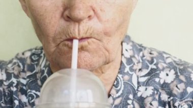 yaşlı kadın bir saman closeup bir içki içme