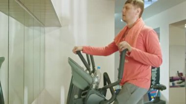 spor salonunda eliptik makine ile adam.
