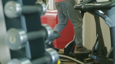 spor salonunda eliptik makine ile adam.