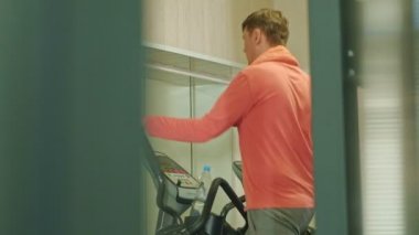 spor salonunda eliptik makine ile adam.