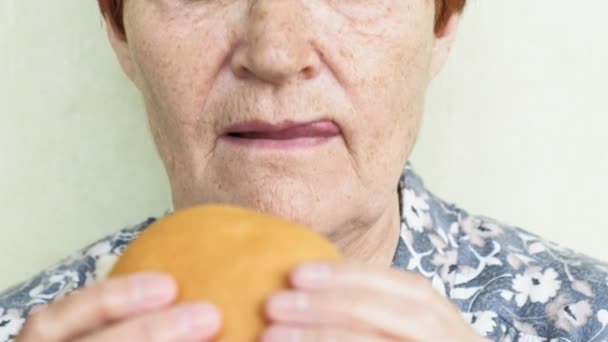 Γριά γυναίκα τρώγοντας Burger κοντινό πλάνο, Φαστ φουντ — Αρχείο Βίντεο