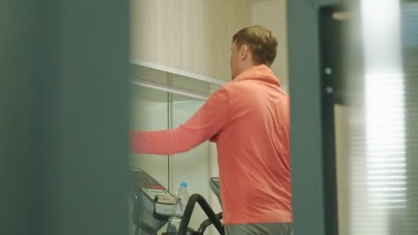 Homem com máquina elíptica no ginásio . — Vídeo de Stock