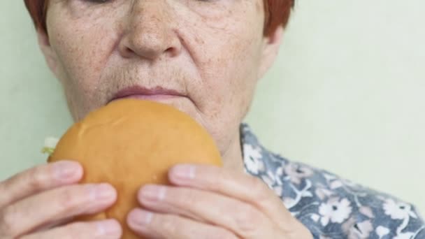 Mulher velha comendo hambúrguer close-up, fast food — Vídeo de Stock