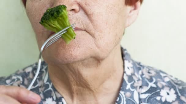 Пожилая женщина есть выбор есть овощи или курицу — стоковое видео