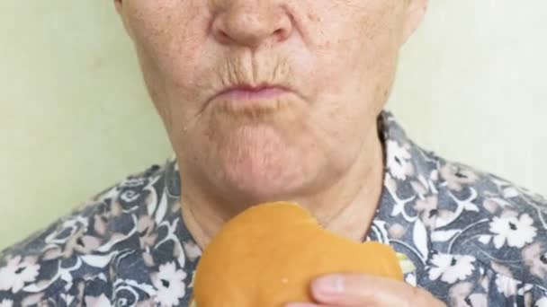 Mulher velha comendo hambúrguer close-up, fast food — Vídeo de Stock