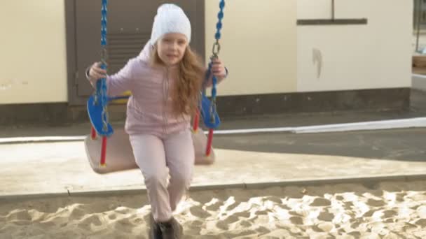 Kleines Mädchen reitet auf einer Schaukel, Frühling — Stockvideo