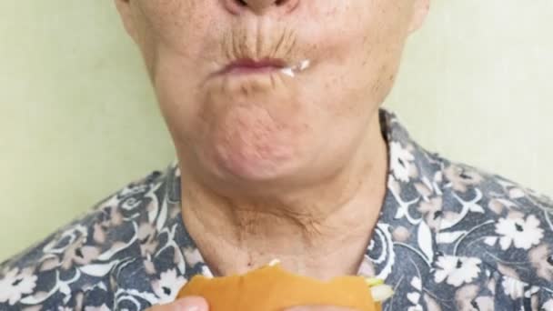 Vieille femme manger hamburger gros plan, restauration rapide — Video