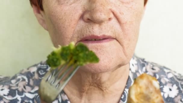Oude vrouw eten keuzes eten groenten of kip — Stockvideo