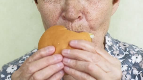 Vecchia donna mangiare hamburger primo piano, fast food — Video Stock
