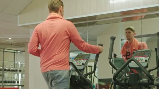 Homme avec machine elliptique dans la salle de gym . — Video