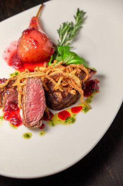 Beyaz tabakta armutlu et libiftek. Koyu ahşap arka plan. Restoran yemekleri.