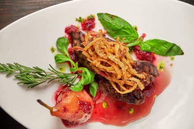 Beyaz tabakta armutlu et libiftek. Koyu ahşap arka plan. Restoran yemekleri.