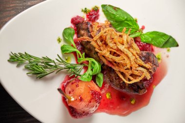 Beyaz tabakta armutlu et libiftek. Koyu ahşap arka plan. Restoran yemekleri.