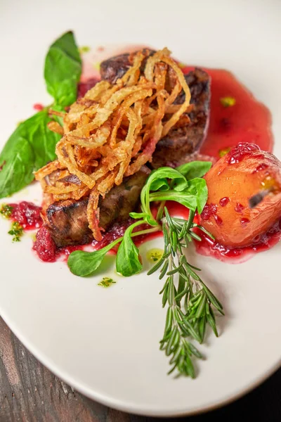 Vlees Steak met peer op een witte plaat. Donkere houten achtergrond. Restaurant eten. — Stockfoto