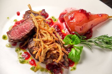 Beyaz tabakta armutlu et libiftek. Koyu ahşap arka plan. Restoran yemekleri.