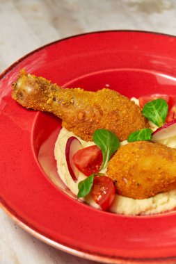 Tavuk bacakları yanında patates püresi var. Açık ahşap arka plan. Restoran menüsü