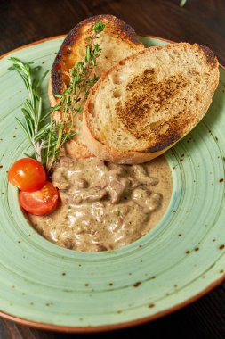 Krutonlu sığır stroganoff. Koyu ahşap arka plan. Restoran menüsü