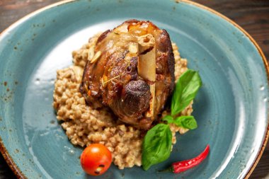 Mavi bir tabak üzerinde bir garnitür ile Knuckle et çanak. Koyu ahşap arka plan.