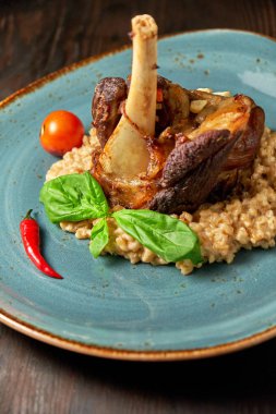 Mavi bir tabak üzerinde bir garnitür ile Knuckle et çanak. Koyu ahşap arka plan.