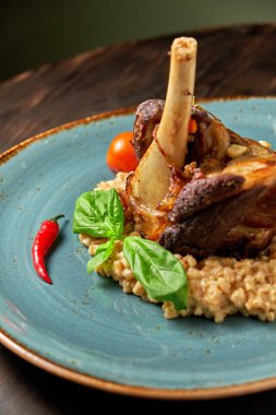 Mavi bir tabak üzerinde bir garnitür ile Knuckle et çanak. Koyu ahşap arka plan.