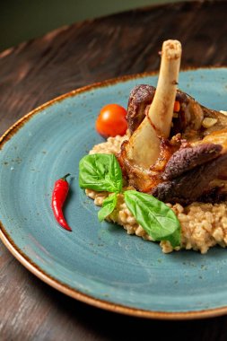 Mavi bir tabak üzerinde bir garnitür ile Knuckle et çanak. Koyu ahşap arka plan.