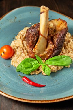 Mavi bir tabak üzerinde bir garnitür ile Knuckle et çanak. Koyu ahşap arka plan.